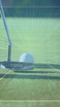 Vertical video: Putter head moving, striking golf ball, sending it rolling on green with flares