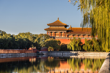 Naklejka premium Sunrise view of Forbidden City watch tower next to surrounding scenic moat to ensure security of the palace, Beijing China.
