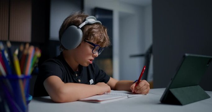 Focused Student Studying At Home. Individual Immersed In Notetaking Amid Home Study Environment