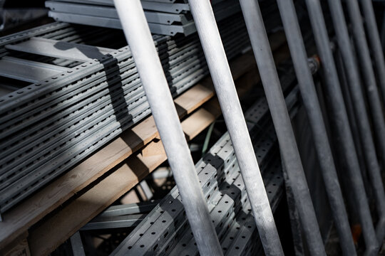 Industrial metal construction materials and steel scaffolding poles organized in a storage facility for urban development projects and professional architectural site logistics