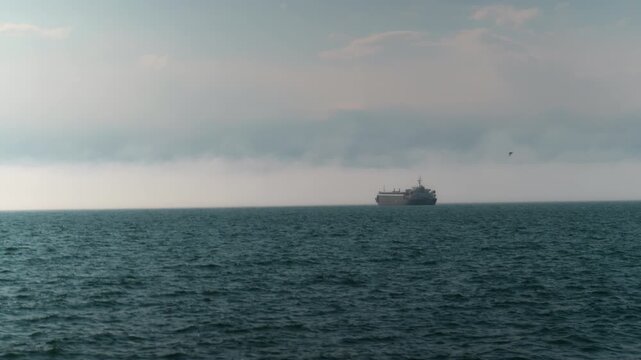 tropical seascape of sailing kargo tanker ship in sea with dark clouds