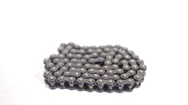 Metal roller chain rotating on a white surface, close-up footage high-quality professional detailed.mp4