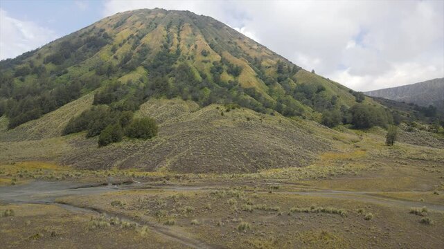4K aerial view of the iconic Mount Batok with its lush green ridges and volcanic caldera floor.