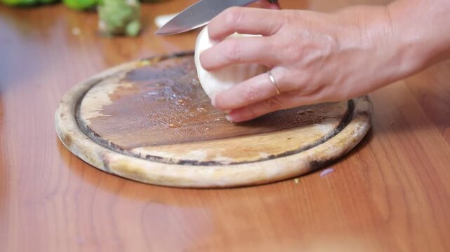 Chef cutting fresh mozzarella cheese on board