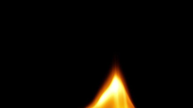 An extreme close-up of a fire flame burning low and wide against a black background, the flames shifting and dynamically pulsating and moving to the side to reveal glowing orange embers.