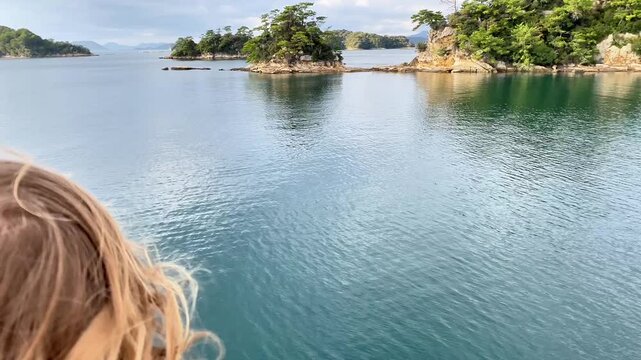  Child's Windblown Hair Overlooking a Scenic Bay and Islands