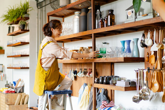 woman staff checking merchandise stock inventory count display shelf using clipboard in household retail shop, Asian worker examine product quality price tag in store warehouse family small business