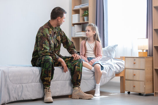 father soldier and daughter serious between conversation, child sitting on bed with defensive posture.