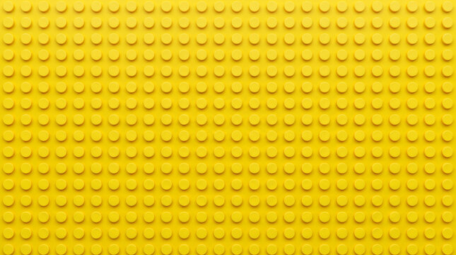 Yellow plastic building block baseplate texture, vibrant toy construction bricks background, seamless pattern of interlocking plastic studs