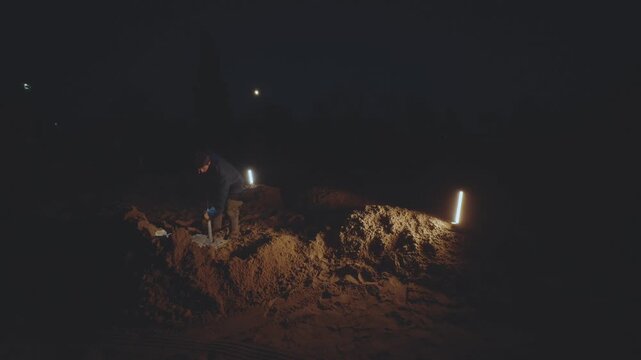 Digging sand, digging sand at night, digging up a pile of sand