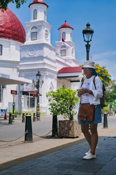 Female tourist standing opposite a vintage old church called Gereja Blenduk in Semarang, Central Java