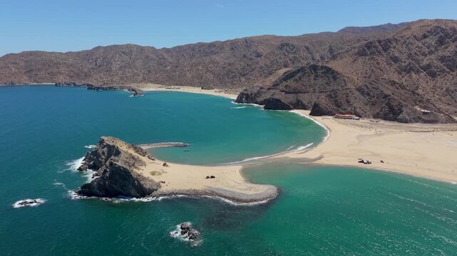 Aerial view of an SUV with a teardrop camper trailer parked on an island beach in Punta Final, Bahia de Gonzaga, Baja California, Mexico