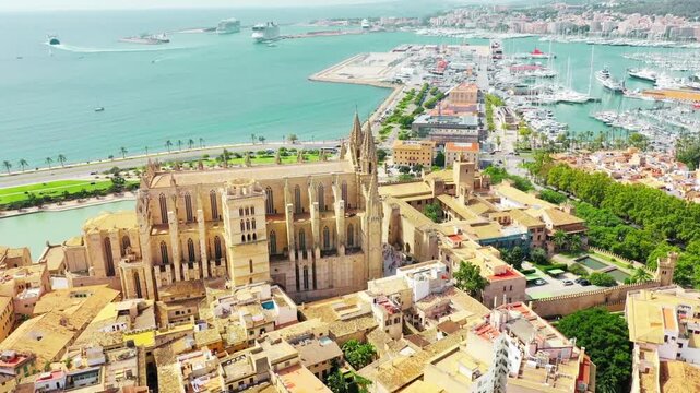 Aerial drone footage of La Seu Cathedral in Palma de Mallorca, Spain showcasing iconic Gothic architecture, historic landmark views, and stunning Mediterranean cityscape.