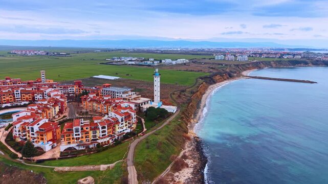 Marina Cape Complex and the Aheloy lighthouse at the shore of the Black Sea in Bulgaria. Footage over the waterscape on gloomy day.