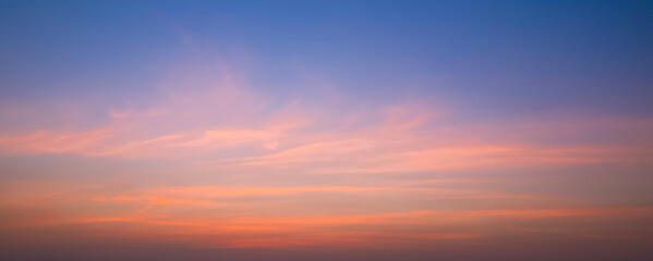 Obraz premium Evening Sky Panoramic Background with Orange and Pink Soft Clouds on Blue Nature Sunset Sky, Colorful Tropical Sunrise Natural Backdrop