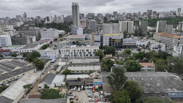 Drone flies backwards from city to over the Mbuluzi River on an overcast day in Maputo, Mozambique