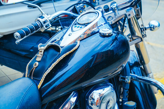 Cruising motorcycle tank with a dashboard console and chrome accents reflecting the environment