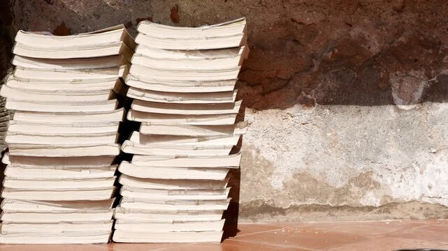Old book stack in front of old wall