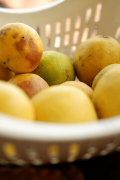 Close up of Ripe Yellow Citrus Fruits Inside a Rustic Wicker Basket