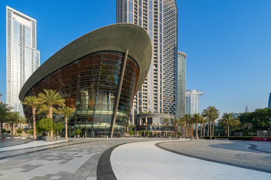 Modern Architecture of Dubai Opera House with Dhow-Inspired Glass Design, Surrounded by Palm Trees and Downtown Skyscrapers under Clear Blue Sky, Dubai, UAE