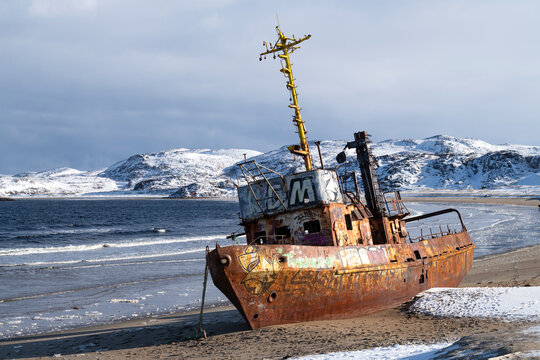 TERIBERKA, RUSSIA - MARCH 12, 2025: Old abandoned seiner on the shore of the Barents Sea on a March day