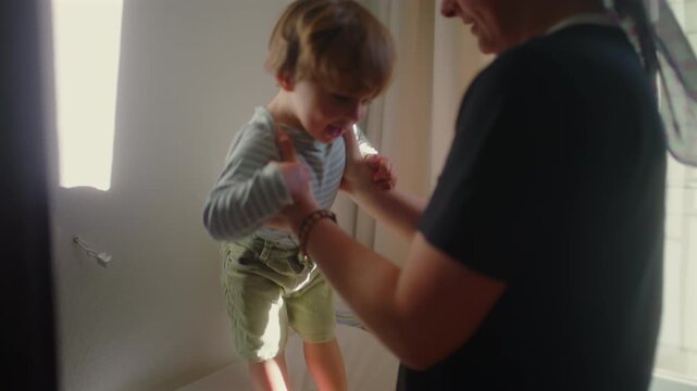 Happy toddler jumping on bed near window at home, joyful childhood play and energy, playful movement and carefree moment in bright indoor family setting