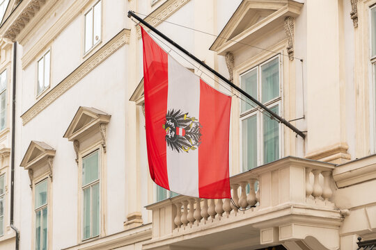 April 15, 2026, Vienna, Austria. Austrian flag with eagle emblem on historic fa&ccedil;ade