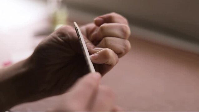 Person Filing Fingernails with a Nail File Indoors, Close-up Manicure Routine, Static Shot