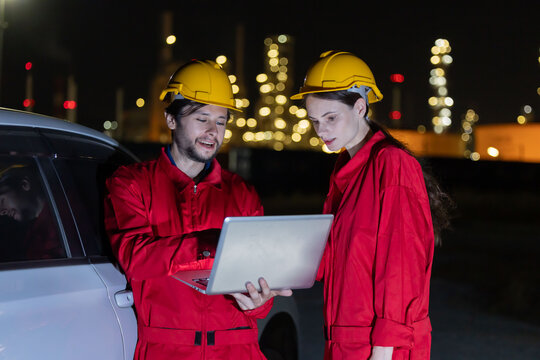 Petroleum engineers working at oil refinery site at night