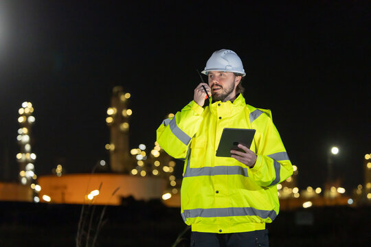 Petroleum engineers working at oil refinery site at night