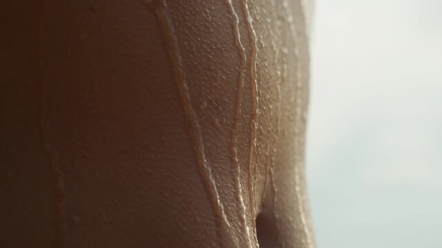 Streaming water along athletic torso, postworkout shower scene, muscle contours highlighted by cool backlight, droplets sliding slowly, studio energy with refreshing intense mood
