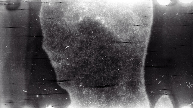 Blank grained film strip texture background with heavy grain, dust and light leak. Old expired soviet moldy photographic film scan. Black and white.