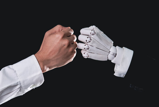 Human hand and robotic hand giving fist bump for AI partnership concept