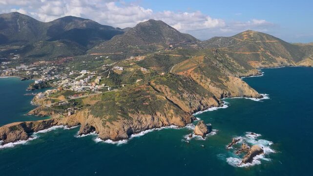 4K aerial panoramic view of Bali bay in Crete, Greece. Panning shot of rugged rocky coastline, turquoise sea and high mountains on background. Scenic Mediterranean landscape at morning