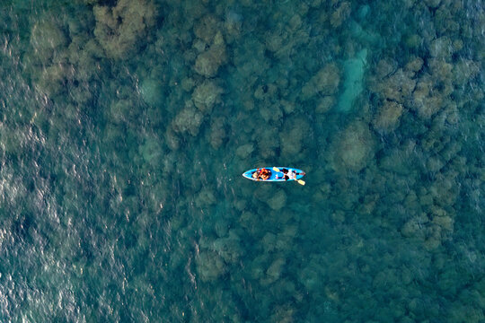 Aerial view of a kayak in the blue sea. Men kayaking Water sports fishing activities.