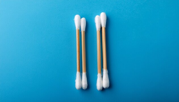 two wooden cotton swabs for daily hygiene on blue background