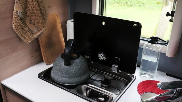 Kettle Boiling on Gas Stove in Compact RV Kitchen.