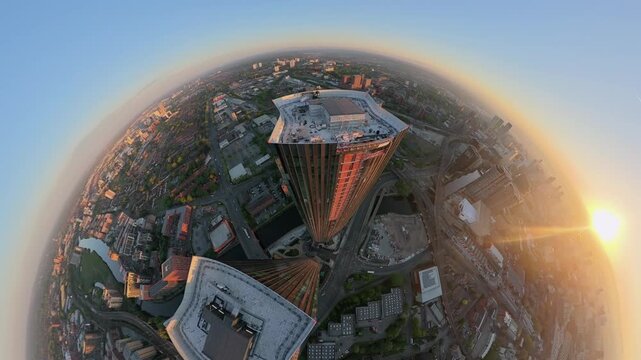 Creative 360 degree tiny planet aerial video of Manchester city skyscrapers at sunrise