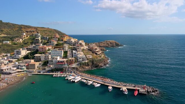 Aerial drone view of Bali bay and beach in Crete, Greece. Scenic turquoise harbor with fishing boats, yachts and emerald water at morning sun. Authentic coastal village landscape, no people, 4k.