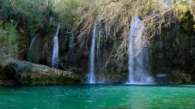 Beautiful Nature Scene Waterfall and Lake Landscape. Cinematic Waterfall Falling into Clear Lake. Tranquil Waterfall and Lake in Forest Setting.