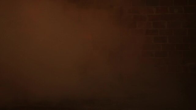 Dense orange smoke swirling in front of a brick wall