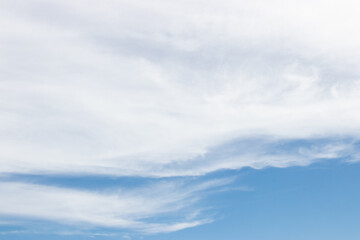 Obraz premium Abstract nature background of soft white clouds spread across a light blue sky during the daytime, creating a peaceful and airy atmosphere