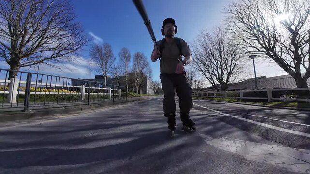 athletic man rollerblading on urban road with action camera capturing fast skating movement and outdoor fitness energy, adrenaline extreme sport