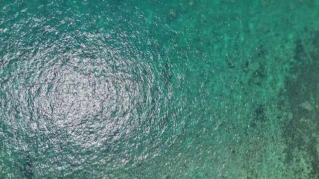 Aerial View of Shimmering Turquoise Sea Water with Sunlight Reflecting on Ocean Surface, Creating Tranquil and Mesmerizing Texture