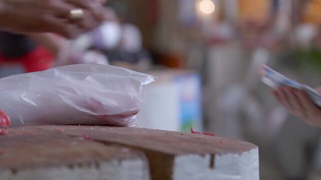 Primer plano de manos de carnicero cortando bistec de res fresco en mercado tradicional - 4K