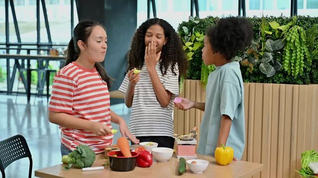 Three happy diverse young girls having fun tasting food while playing pretend cooking together