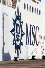 Fototapeta premium Fuerteventura, Spain, April 7, 2026 - Detail of MSC cruises logo and portholes on hull, with pier bollards and ropes in front