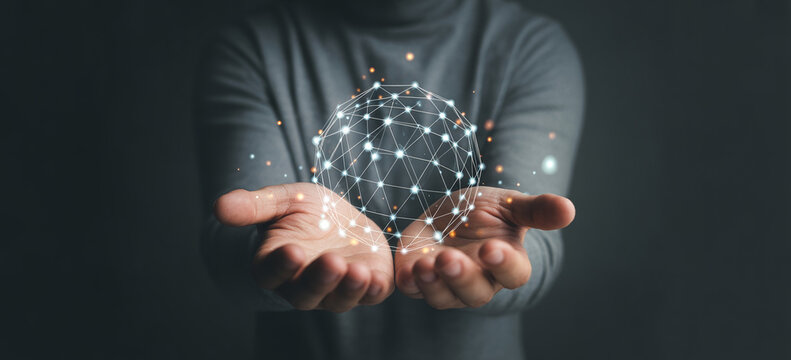 Hands holding glowing digital geometric structure globe representing networking and global technology connections.