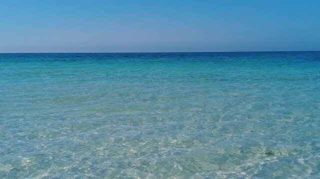 Beautiful crystal clear turquoise ocean with gentle ripples beneath a clear sky on a sunny day near Palmetto Beach, Anna Maria Island, Florida, U.S