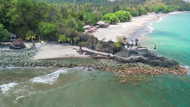 Stunning overhead panorama of Batu Bolong temple near Senggigi beach featuring Balinese architecture black lava rock and turquoise sea
